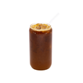 Iced black tea in a clear glass with ice cubes and straw on a white background