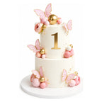 Two-tiered Pink Butterfly Garden Cake with delicate pink butterflies, gold spheres, and floral decorations, featuring a gold number one on the top tier for a first birthday celebration.