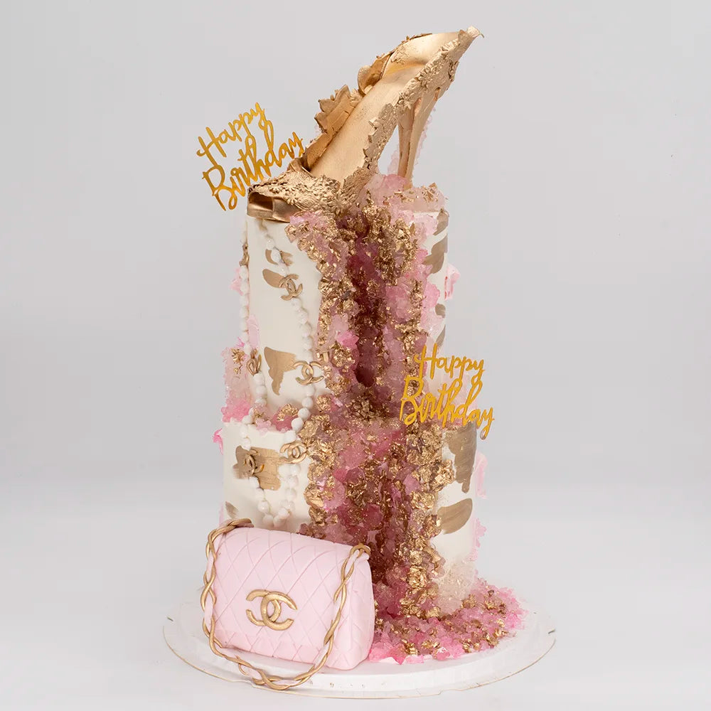 Luxury birthday cake with gold high heel topper, pink crystals, gold accents, and purse decoration