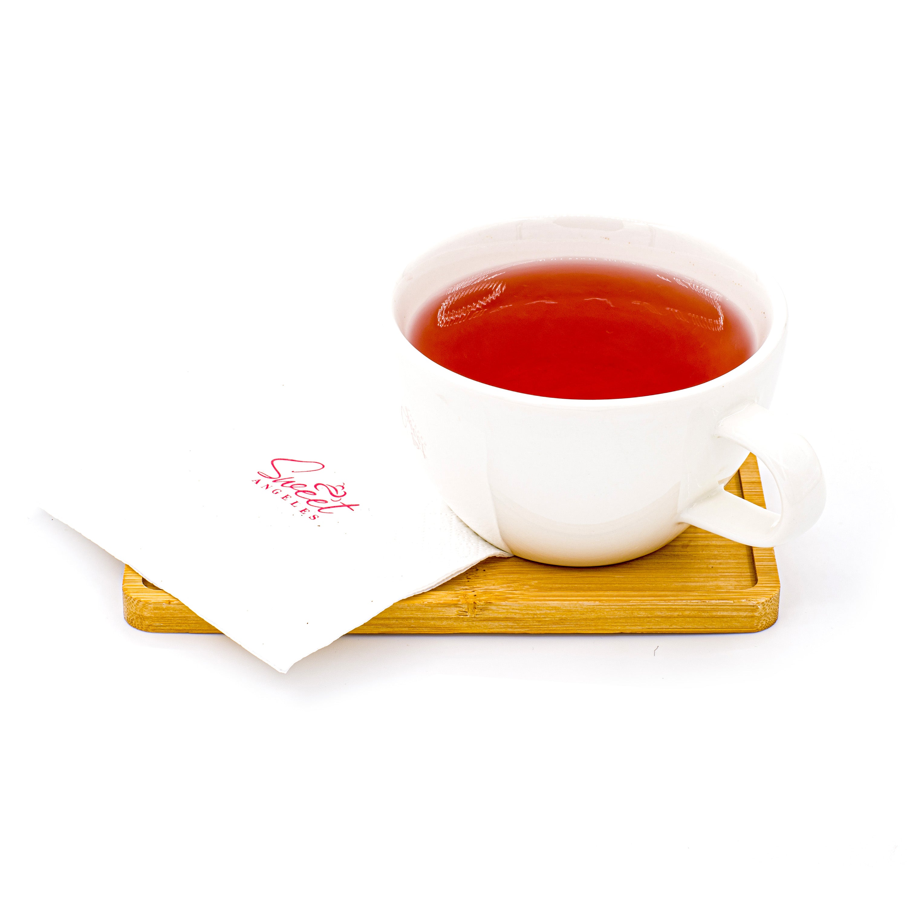 Cup of red herbal tea in white mug on wooden tray with branded napkin