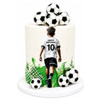 All Sports Champion Cake featuring a white frosted design with green accents, decorated with soccer balls and a figure of a soccer player wearing a jersey with "Happy Birthday 10".
