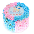 She Or He Cake decorated with pink and blue frosting swirls and gold accents, featuring a gender reveal design with baby bottles and question marks.