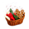 Wicker basket filled with festive Christmas cookies shaped like trees, stockings, and gingerbread people.