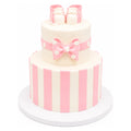 Two-tier custom cake decorated with vertical pink and white stripes, a pink bow with white polka dots, and topped with pink stripe baby booties cake accents.